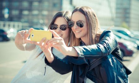 2 girls taking selfie on phone