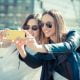 2 girls taking selfie on phone