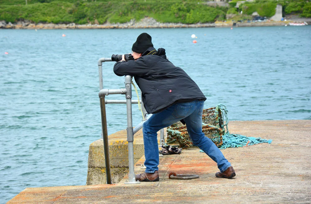 Photographer at harbour searching for the perfect image