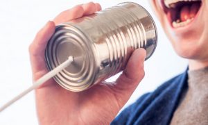 man speaking on tin can phone