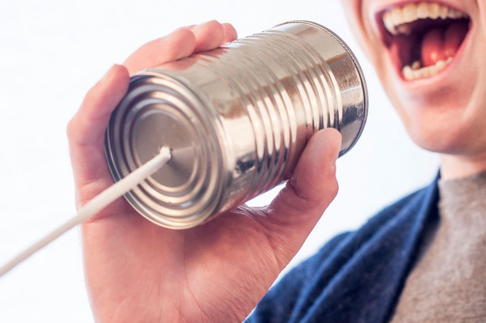 man speaking on tin can phone