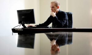 Business man reading proposal on computer screen