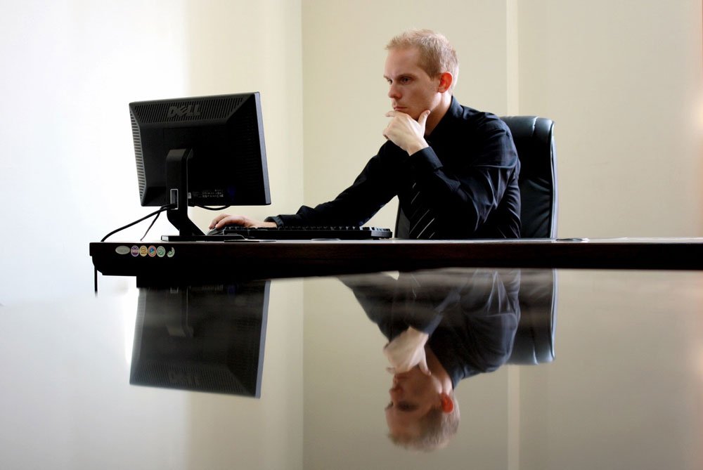 Business man reading proposal on computer screen