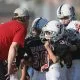 Footbal coach talking to group of young players