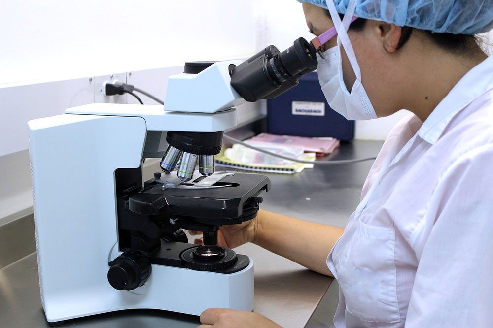 Scientist looking down microscope