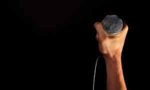 presenter holding microphone to start speech