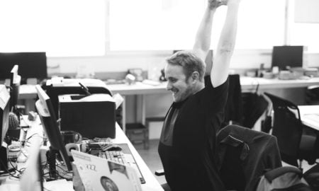 presentation designer stretching at desk