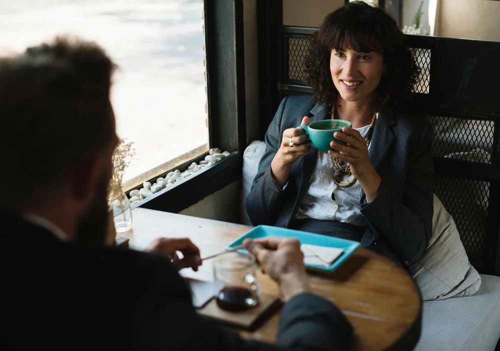 2 business people having conversation over coffee