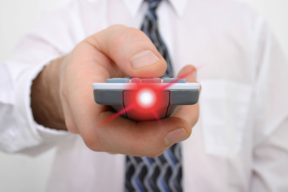 presenter in white shirt point presentation remote control with red laser light