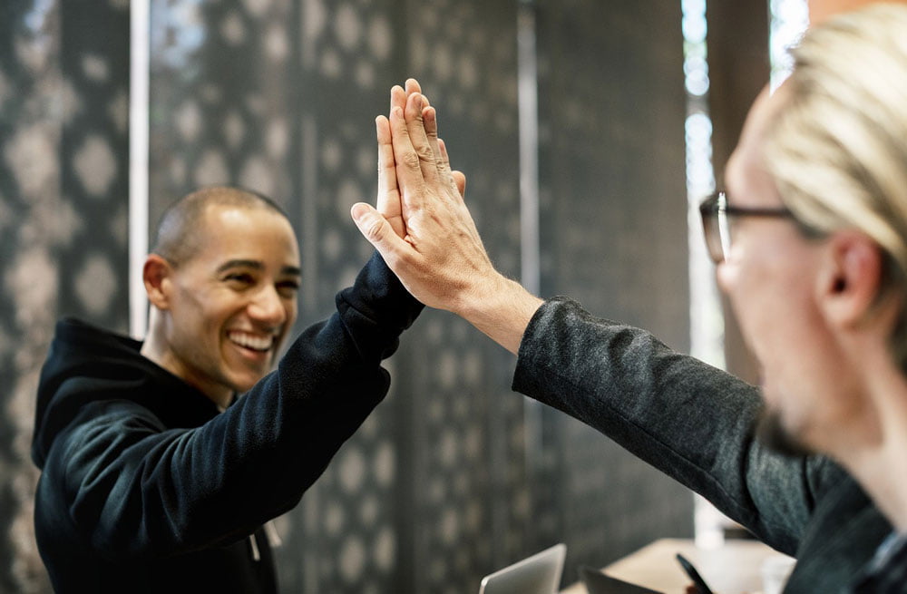 young man and older lady high fiving each other