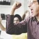 man cheering at computer screen