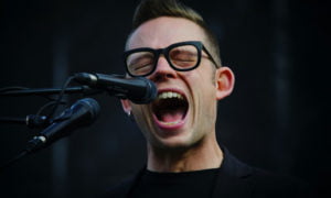 man performing vocal exercise shouting into microphone