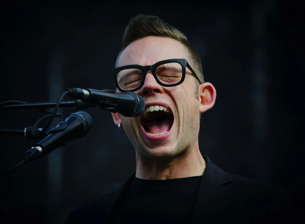 man performing vocal exercise shouting into microphone