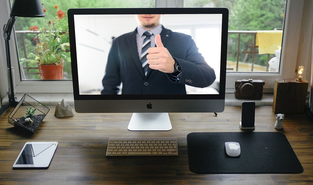 male presenter on webinar screen giving thumbs up